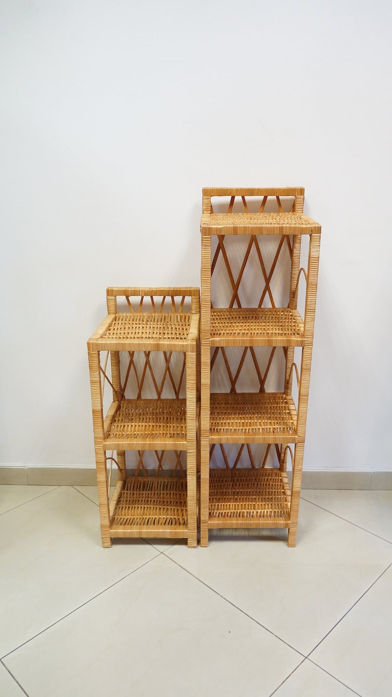 May include: Two wicker shelves, one taller than the other, with a woven design. The shelves are made of natural brown wicker and have four shelves each.