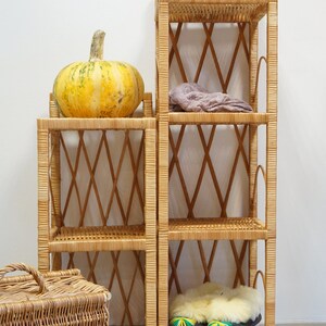 May include: Two wicker shelves with a pumpkin on top of one and a stuffed animal on top of the other. The shelves are made of woven wicker and have a diamond pattern. The shelves are standing on a tiled floor.