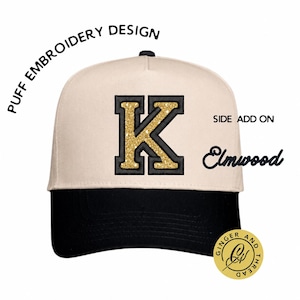 May include: A cream-colored baseball cap with a black brim and a large, central letter K featuring gold glitter and a black border. The text PUFF EMBROIDERY DESIGN, SIDE ADD ON, Elmwood, and a circular GINGER AND THREAD logo are visible.