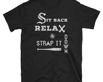 May include: Black t-shirt with white text that reads "Sit Back Relax & Strap It Down" with a baseball bat graphic.
