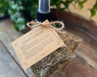 May include: A small brown paper bag with a twine bow, containing dried herbs, and a clear spray bottle with a black cap. The bag has a label that reads "Herbal Conditioner" with instructions for use.