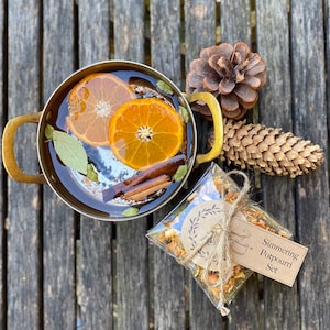 May include: A simmering potpourri set with a brass pot filled with water, orange slices, cinnamon sticks, and bay leaves. The set also includes a small bag of dried orange peels, cinnamon sticks, and other spices.