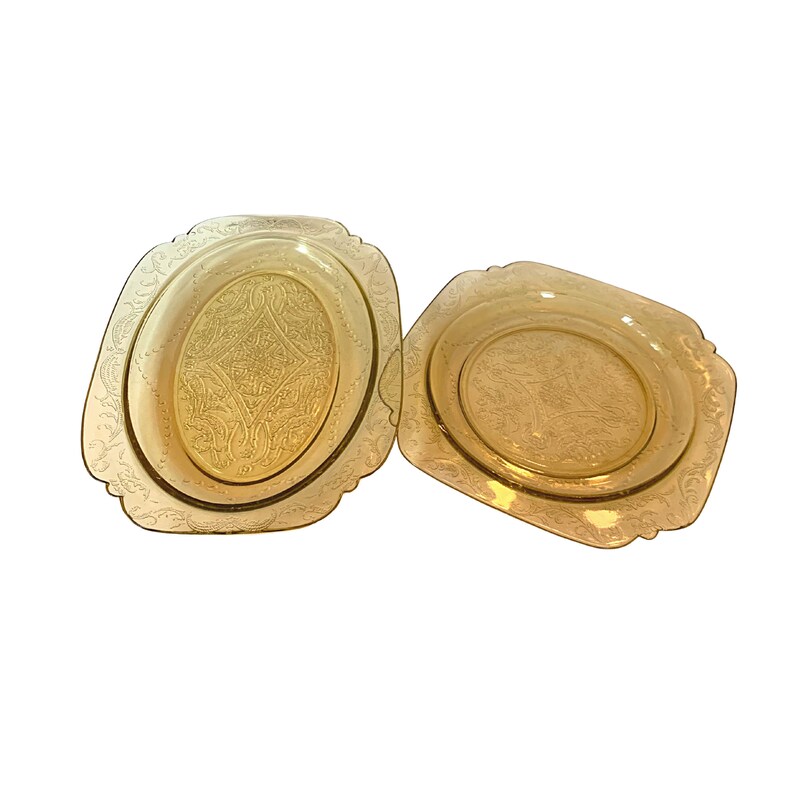 May include: Two vintage yellow glass serving dishes with an etched floral design. The dishes are oval and square shaped.
