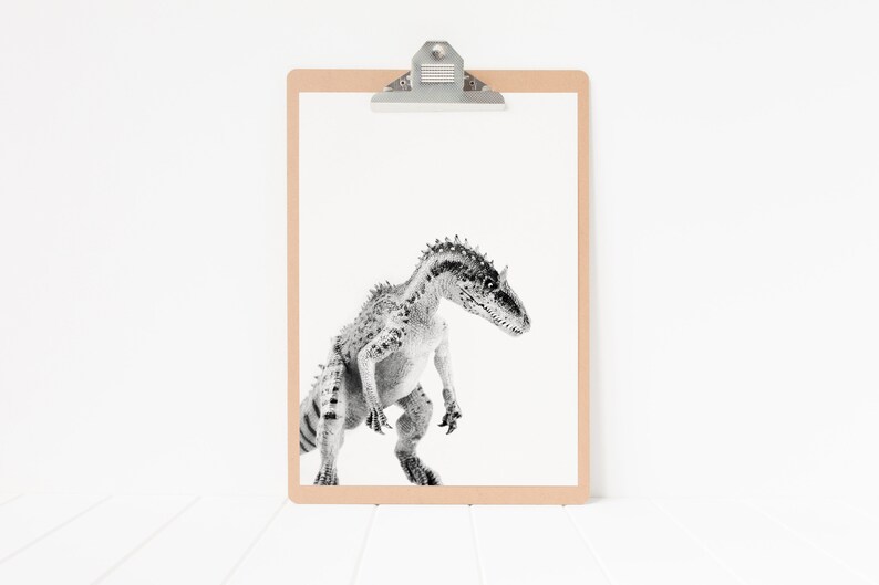 May include: A black and white illustration of a dinosaur on a clipboard with a brown frame.
