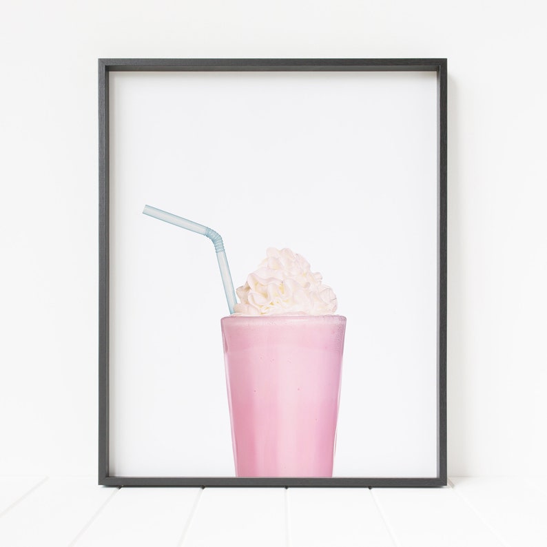 May include: A pink milkshake with whipped cream and a blue straw in a clear glass. The milkshake is in a black frame.