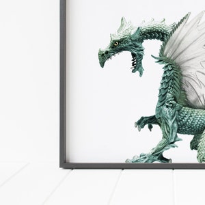 May include: A green dragon figurine with white wings, posed in a standing position with its mouth open. The dragon is in a framed picture.