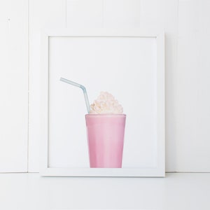 May include: A pink milkshake with whipped cream and a blue straw in a clear glass. The milkshake is in a white frame.