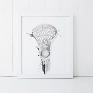 K&ouml;nnte beinhalten: Ein wei&szlig;er Lacrosse-Schl&auml;ger mit einem wei&szlig;en Ball im Netz. Der Schl&auml;ger ist scharf gestellt und der Hintergrund ist verschwommen.