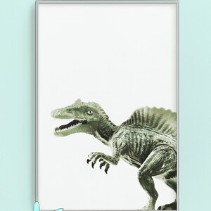 May include: A framed print of a green dinosaur with a white background. The dinosaur is facing the right side of the image. The frame is silver.