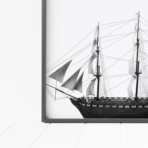 May include: Black and white illustration of a sailing ship with multiple sails. The ship is drawn in detail with ropes and rigging.