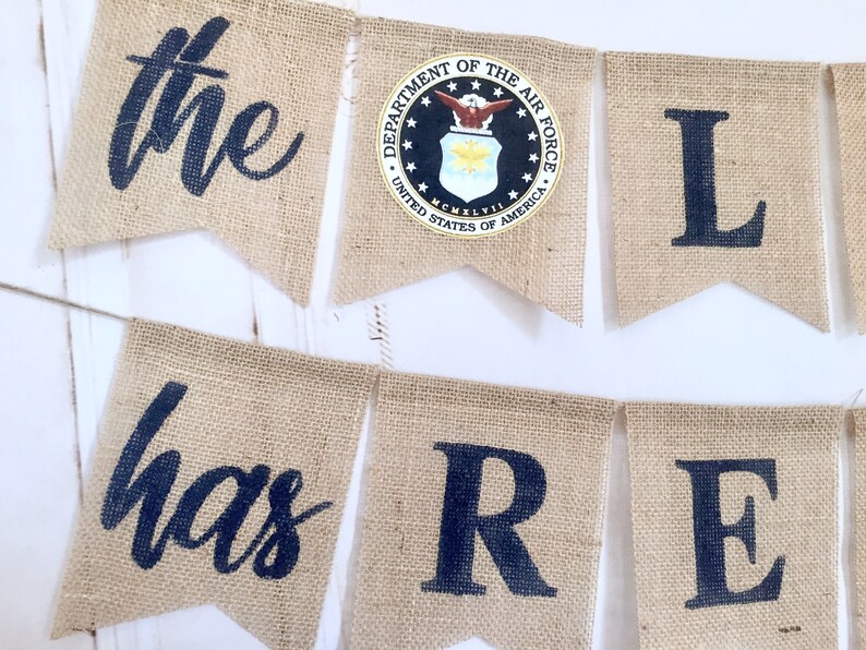 May include: A burlap banner with the words "the has re" and the seal of the Department of the Air Force, United States of America.