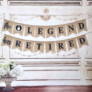 May include: A burlap banner with the text "the LEGEND has RETIRED" in black lettering. The banner has a small blue and white emblem of the United States Air Force.