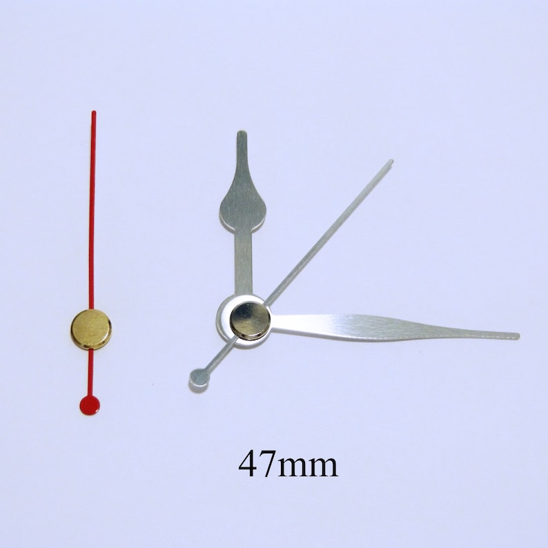 May include: A set of clock hands with a gold-colored center and a red second hand. The minute hand is 47 mm long.