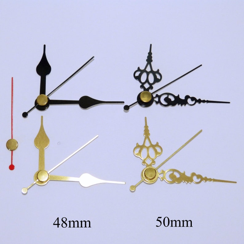 May include: Four clock hands, two black, two gold, with gold accents. The hands are 48mm and 50mm long.