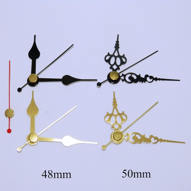 K&ouml;nnte beinhalten: Vier Uhrzeiger, zwei schwarz, zwei goldfarben, mit goldenen Akzenten. Die Zeiger sind 48 mm und 50 mm lang.