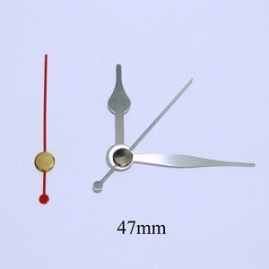 K&ouml;nnte beinhalten: Ein Satz Uhrzeiger mit goldfarbenem Zentrum und einem roten Sekundenzeiger. Der Minutenzeiger ist 47 mm lang.