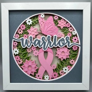 May include: A pink and green paper craft with a pink ribbon and butterfly. The word "warrior" is written in gray letters on a white background.