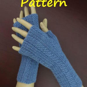 Könnte beinhalten: Ein Paar blaue fingerlose Handschuhe mit einem strukturierten Strickmuster. Die Handschuhe werden auf einer Schaufensterpuppenhand präsentiert. Das Wort "Pattern" steht gelb oben im Bild.