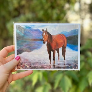 PINTURA AL ÓLEO Caballo rojo con cara blanca marcada de pie en un lago con rocas de colores y un hermoso fondo / Lago McDonald / Por Noelle Perry