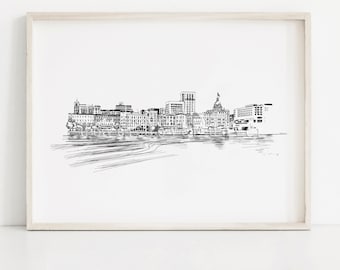 May include: A framed black and white pen and ink drawing of a city skyline. The artwork shows a detailed cityscape with buildings, a river, and a clear sky. The style is illustrative, with a light wood frame.