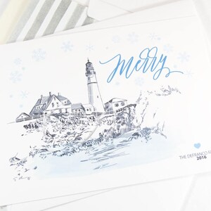May include: White greeting card featuring a lighthouse illustration with the word "merry" in blue script. The card includes snowflakes and the text "The DeFranco Family 2016". The lighthouse is depicted in black and white with blue watercolor accents.