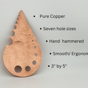 May include: A teardrop-shaped copper tool with seven different sized holes and a serrated edge. The tool is hand-hammered and measures 3 inches by 5 inches.