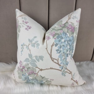 May include: A white pillow with a floral pattern in shades of blue, green, and pink. The flowers are arranged in a delicate, whimsical design.