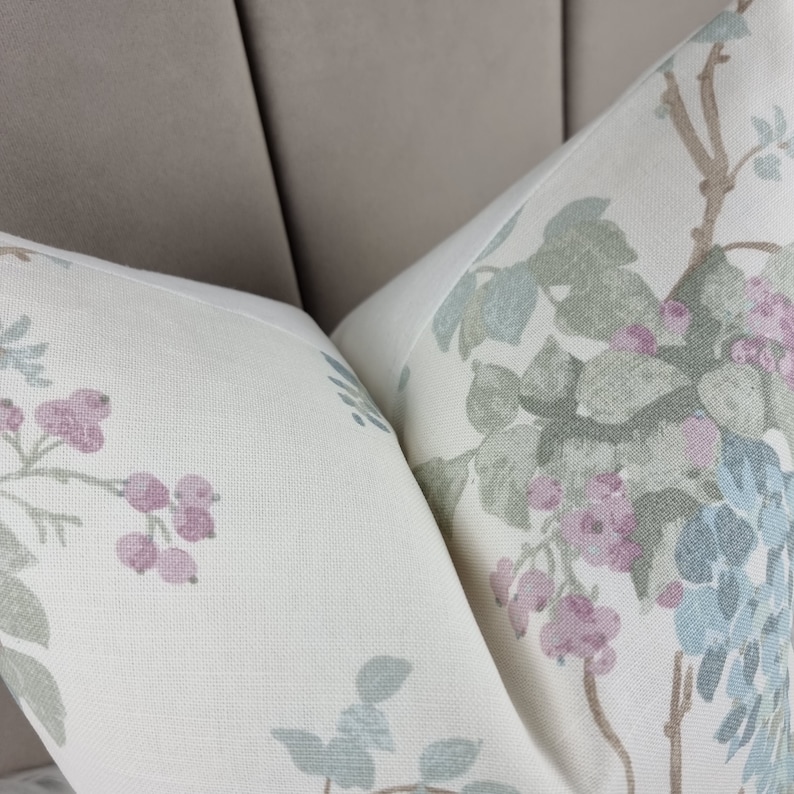May include: Two white pillowcases with a floral pattern. The pillowcases feature a light green, blue, and pink floral design with a white background.