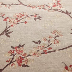 以下が含まれることがあります： ベージュ色の生地に花柄のクローズアップ。濃い茶色の枝に赤とクリーム色の花が咲き乱れています。デザインはテクスチャード加工されています。