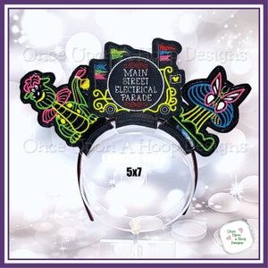 May include: A black headband with colorful embroidered designs featuring a butterfly, a carriage with the text "Main Street Electrical Parade", and a green and pink creature. The headband is 5x7 inches.