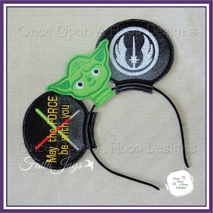 May include: Black and green embroidered mouse ears with a Yoda character, a lightsaber, and the text "May the Force be with you".