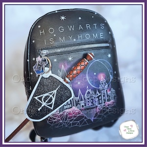 May include: Black backpack with the text "HOGWARTS IS MY HOME" and a graphic of Hogwarts castle. Includes a wand and a Deathly Hallows charm. The bag has a zipper closure and a silver-colored zipper pull.