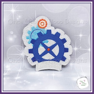 May include: Embroidered iron-on patch featuring a blue gear with a red center and two smaller gears, one blue and one orange. The patch is on a white background.