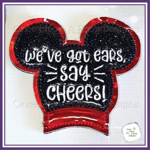 May include: Red and black felt applique with Mickey Mouse ears. The applique has white text that reads "We've got ears, say CHEERS!"