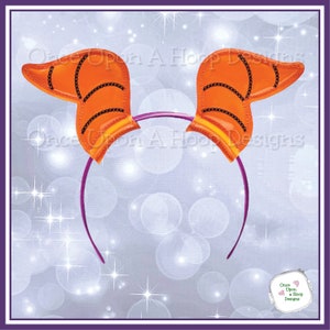Peut inclure: Un serre-tête en feutre orange et noir avec des oreilles en forme d'oreilles de personnage de dessin animé. Le serre-tête est violet.