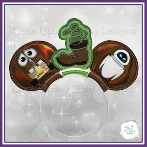 May include: A pair of brown mouse ears with embroidered images of WALL-E, EVE, and a plant growing out of a boot. The ears are attached to a clear plastic headband.