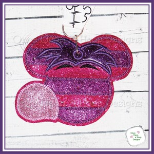 Może przedstawiać: Postać Minnie Mouse z fioletowego i różowego brokatu z fioletową opaską na głowę i różową kokardką. Postać nosi fioletową i różową maskę w paski. Postać jest przymocowana do białej wstążki z napisem "Once Upon A Hoop Designs".