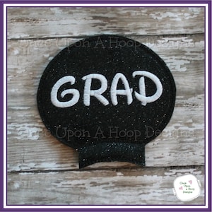 May include: Black glitter circle with the word "GRAD" in white embroidery.