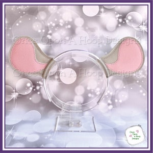May include: A pink and gray mouse ear headband on a clear plastic headband stand. The headband is decorated with a pink and gray fabric mouse ear.