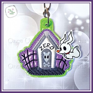 May include: A purple and white dog house with the word "ZERO" above the door. A white ghost with black eyes and a red collar is flying next to the dog house. The dog house is attached to a green key chain.