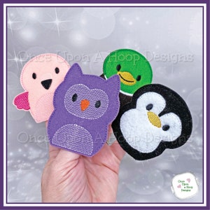 May include: Four felt finger puppets: a pink bird, a purple owl, a green duck, and a black and white penguin. The puppets are on a hand, ready for play.