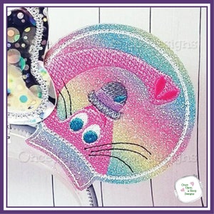 May include: A rainbow glitter fabric ear headband with a pink and white cat face design. The cat has blue eyes and a pink nose.
