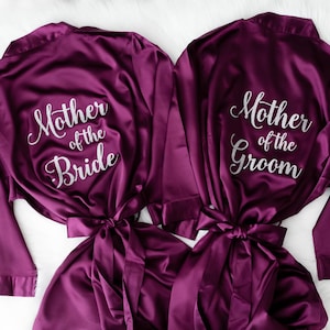 two purple satin robes with the text "Mother of the Bride" printed on them.