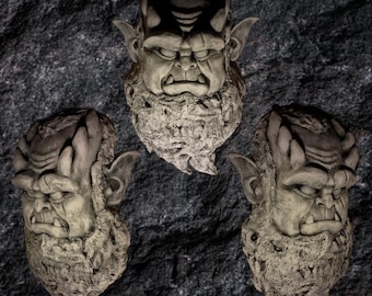 May include: Three stone gargoyle sculptures with a textured surface, each with a different facial expression. The gargoyles have large, pointed ears and a beard-like texture.