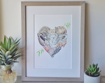 May include: A framed print of a heart-shaped illustration featuring various Australian animals, including a koala, wombat, echidna, and birds. The print is titled "Our Fauna, Our Home" and signed by the artist.
