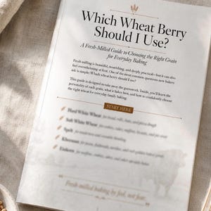 Peut inclure: Un guide imprimé intitulé Which Wheat Berry Should I Use? A Fresh-Milled Guide to Choosing the Right Grain for Everyday Baking. La page présente du texte noir sur fond blanc avec un bouton marron Start Here et une liste de céréales.