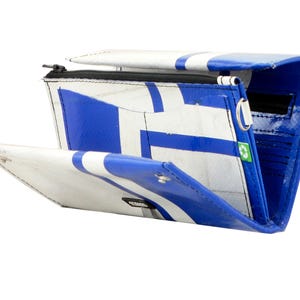 May include: A blue and white wallet made from recycled materials. The wallet has a zipper closure and a snap closure. The wallet is open and the inside is visible. The wallet has multiple compartments for cards and cash.