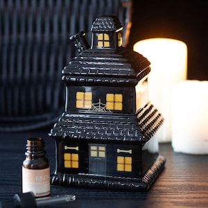 Brûleur à cire en céramique noir de la maison hantée