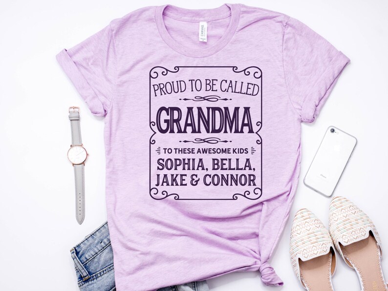 May include: A light purple t-shirt with a black and white graphic that says "Proud to be called Grandma to these awesome kids Sophia, Bella, Jake & Connor".