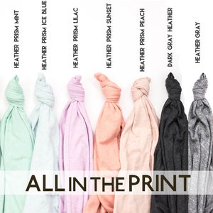 Puede incluir: Primer plano de ocho camisetas de diferentes colores, todas dobladas y anudadas. Las camisetas est&aacute;n etiquetadas con sus nombres de color: Heather Prism Mint, Heather Prism Ice Blue, Heather Prism Lilac, Heather Prism Sunset, Heather Prism Peach, Dark Grey Heather y Heather Grey. El texto "ALL IN THE PRINT" est&aacute; impreso debajo de las camisetas.